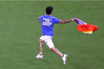 Un aficionado salta al campo con una bandera arcoíris en el Mundial de Qatar
