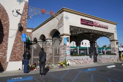 Dos personas hacen una pausa en un monumento fuera del Star Ballroom Dance Studio el lunes 23 de enero de 2023 en Monterey Park, California. Un hombre armado mató a varias personas en el estudio de baile de salón el sábado por la noche en medio de las celebraciones del Año Nuevo Lunar en la comunidad predominantemente asiático-americana . (Foto AP/Ashley Landis)