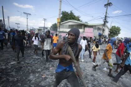 Un manifestante lleva un trozo de madera que simula un arma durante una protesta en la que se exigió la renuncia del primer ministro Ariel Henry en el área de Petion-Ville de Puerto Príncipe, Haití, el 3 de octubre de 2022. (AP Foto/ Odelyn José)