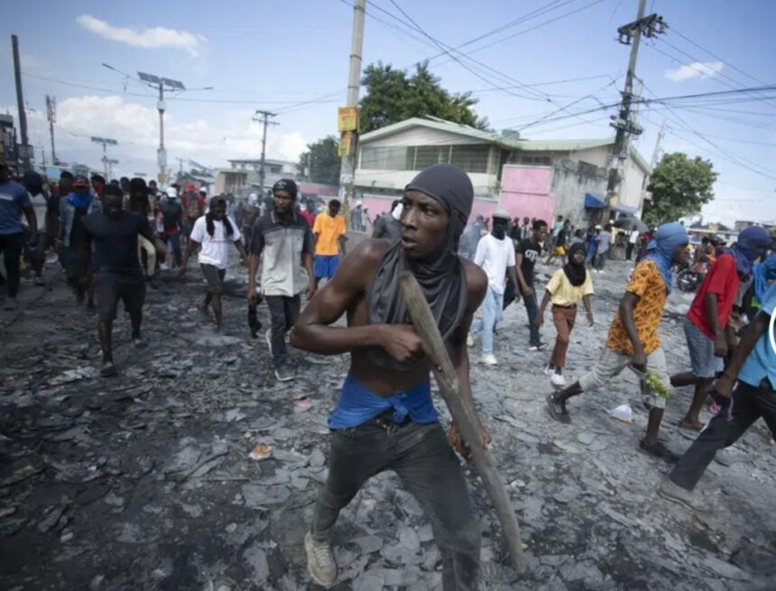 Un manifestante lleva un trozo de madera que simula un arma durante una protesta en la que se exigió la renuncia del primer ministro Ariel Henry en el área de Petion-Ville de Puerto Príncipe, Haití, el 3 de octubre de 2022. (AP Foto/ Odelyn José)